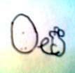 Speckled egg placed next to a small mouse that sitting with a loop in its tail